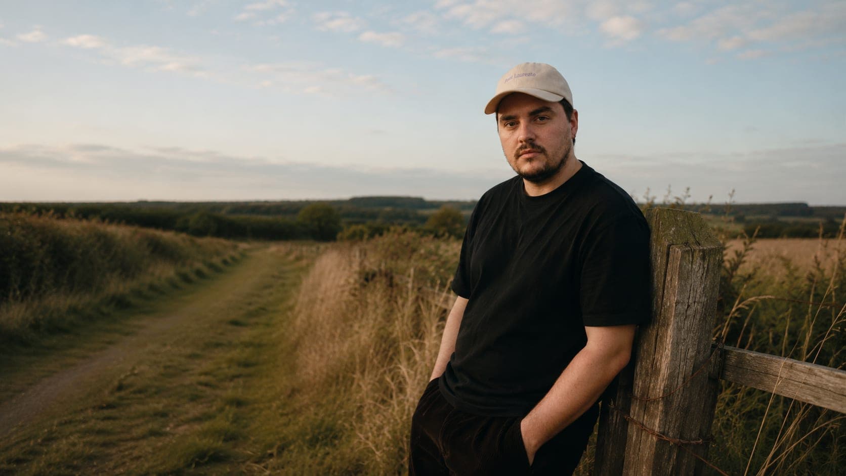 Callum Wells leaning on a fence on a Yorkshire footpath