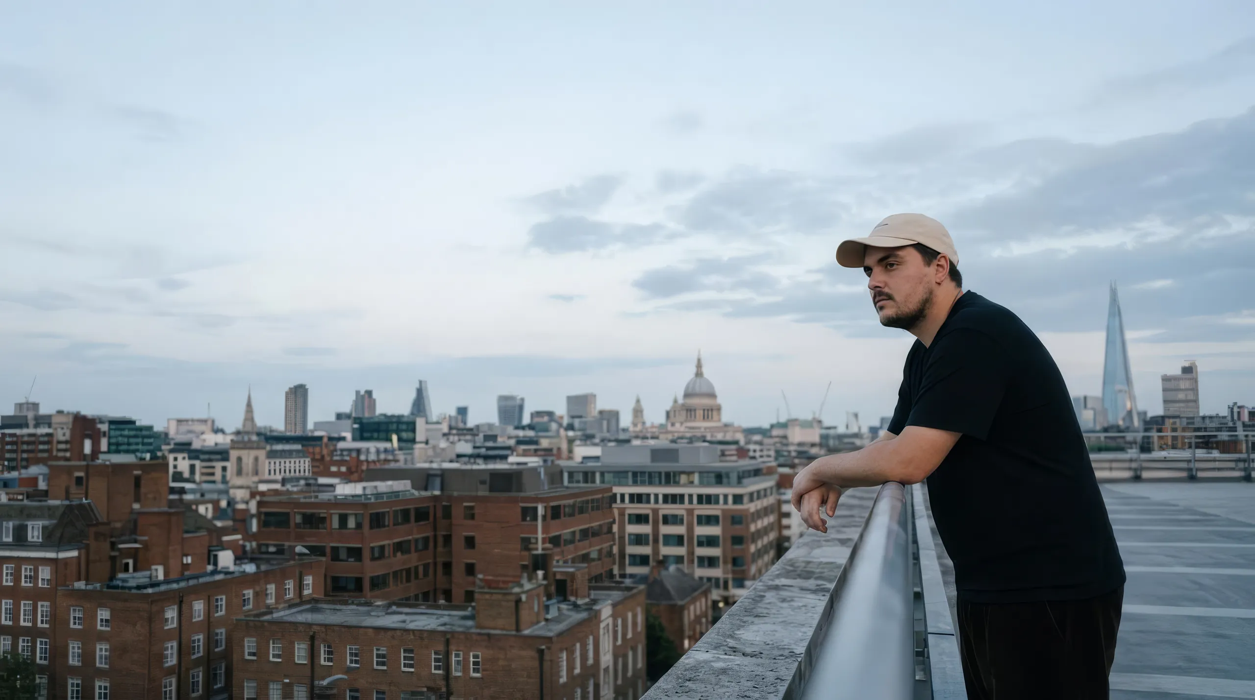 Callum Wells sitting on a fence at golden hour